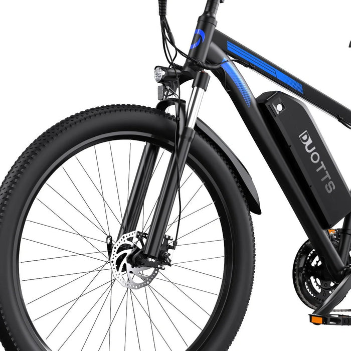 Detaljbild på Duotts C29 Pro elcykel – batteri, främre skivbroms och däckprofil
