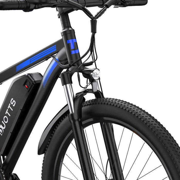 Närbild på Duotts C29 Pro elcykel – framgaffel, LED-strålkastare och grovmönstrat framdäck
